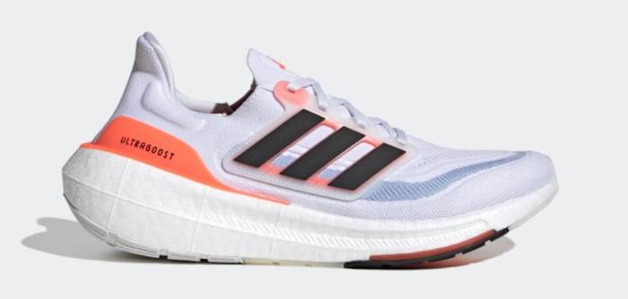 Side view of white, black, and orange adidas running shoe.